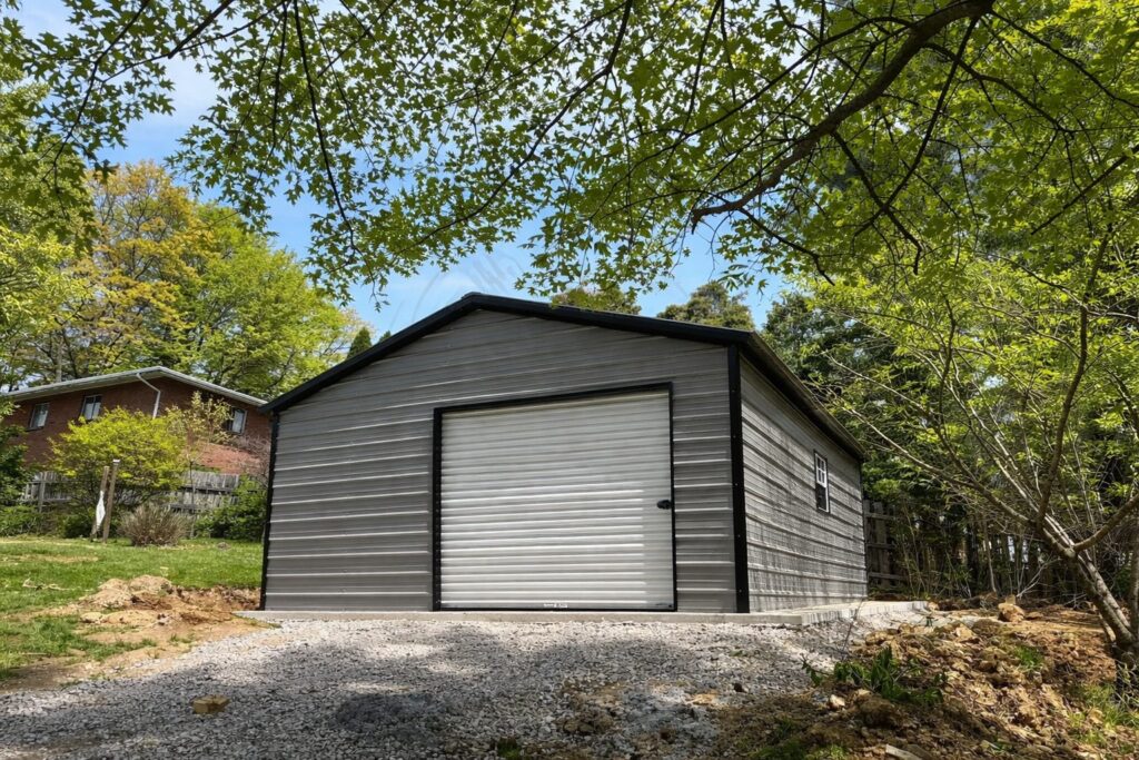 Standard shed in Abbott, TX, featuring a metal exterior and a roll-up door, surrounded by greenery.