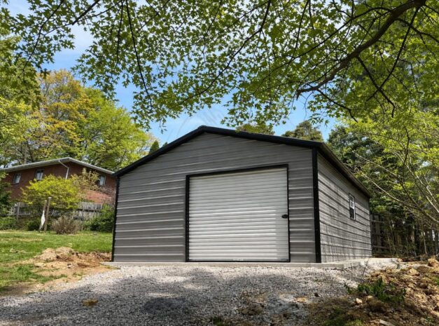 Standard shed in Abbott, TX, featuring a metal exterior and a roll-up door, surrounded by greenery.