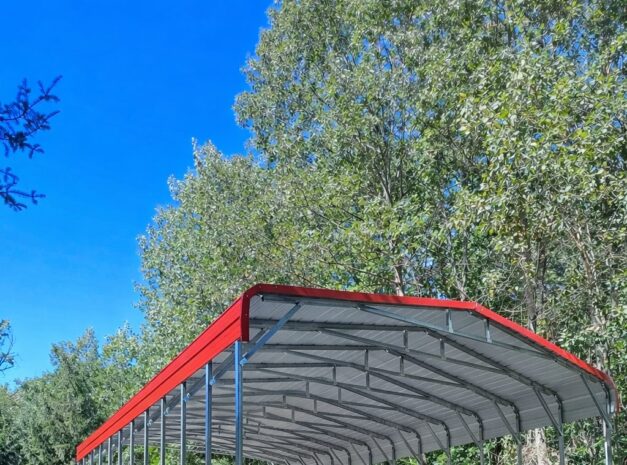 Standard framed carport with a red roof, set on gravel, surrounded by trees in Ashland, KY.