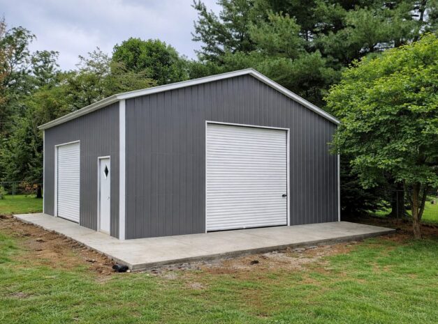 Standard garage in Bad Axe, MI, featuring a gray exterior, large roll-up door, and concrete foundation.