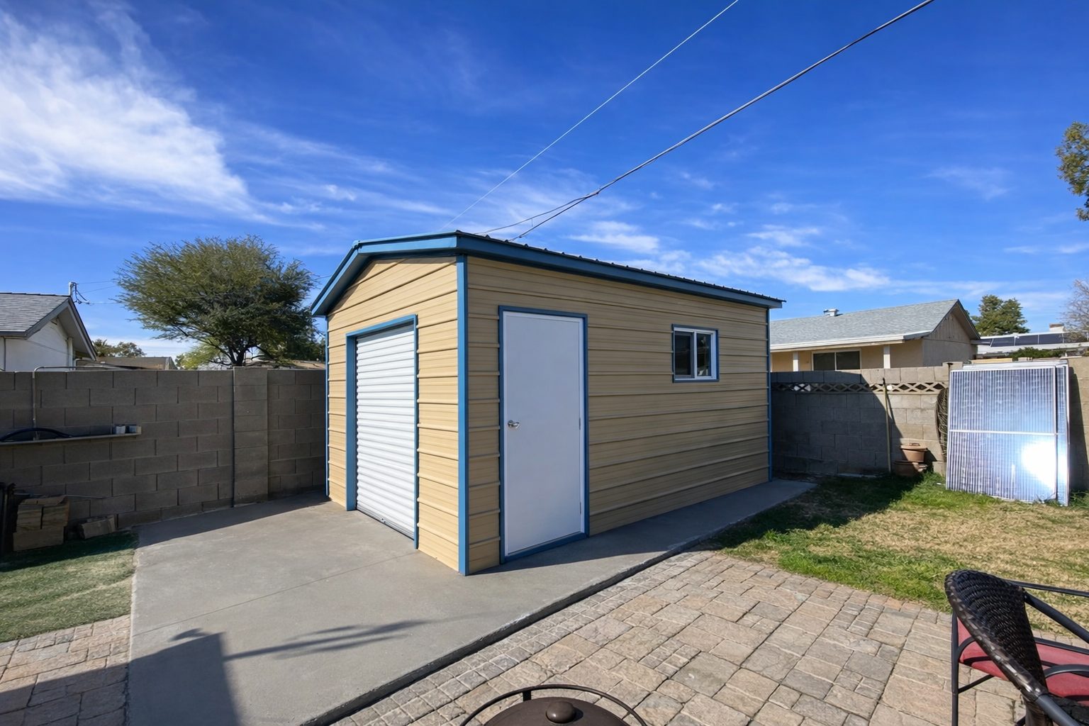 A mini shed in Brady, TX, featuring a light-colored exterior, blue trim, and a front door, set in a backyard.