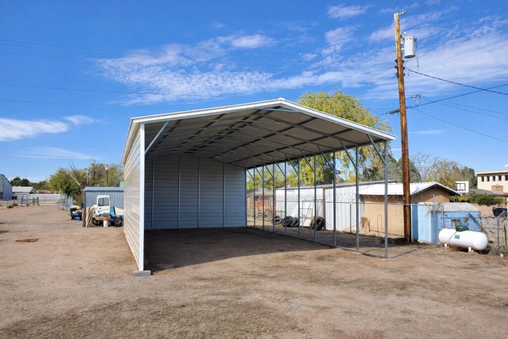 A spacious A-framed carport in Chandler, TX, showcasing a sturdy steel structure with open sides.