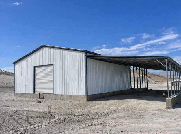 Custom carport structure with a metal frame and a large covered area, set against a clear blue sky.