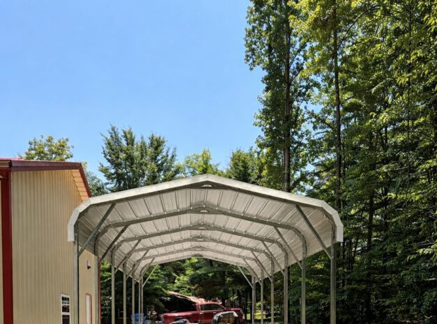Standard carport structure with a gravel driveway, surrounded by trees, showcasing available color options.