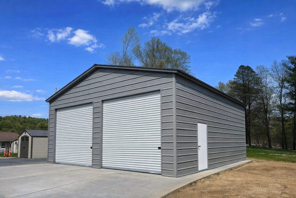 Standard garage in Creston, IA, featuring a gray exterior and large roll-up doors against a clear blue sky.