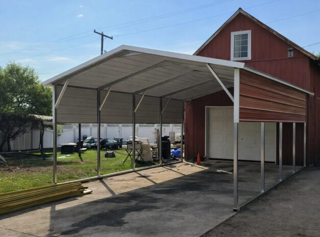 A red barn-style building with an A-framed carport, showcasing available color options for carports in Denton, TX.