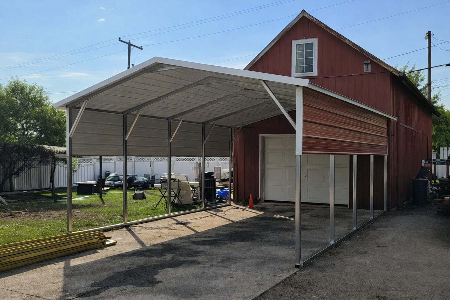 A red barn-style building with an A-framed carport, showcasing available color options for carports in Denton, TX.