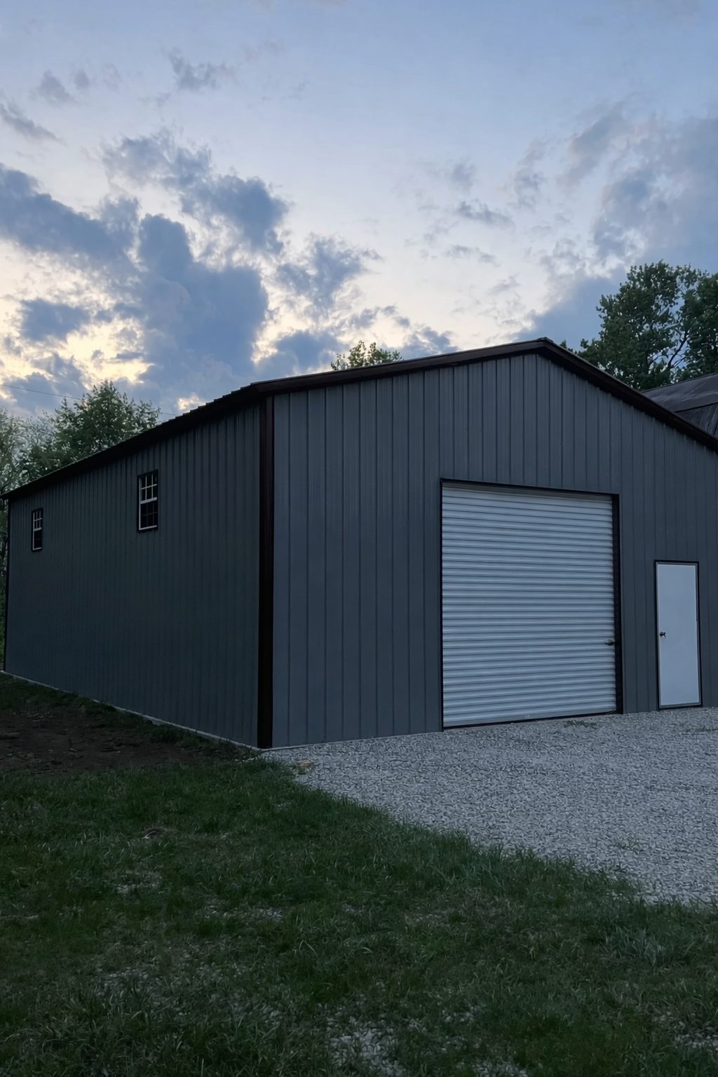 Clear span metal building in Granbury, TX, featuring a large roll-up door and a sleek gray exterior.