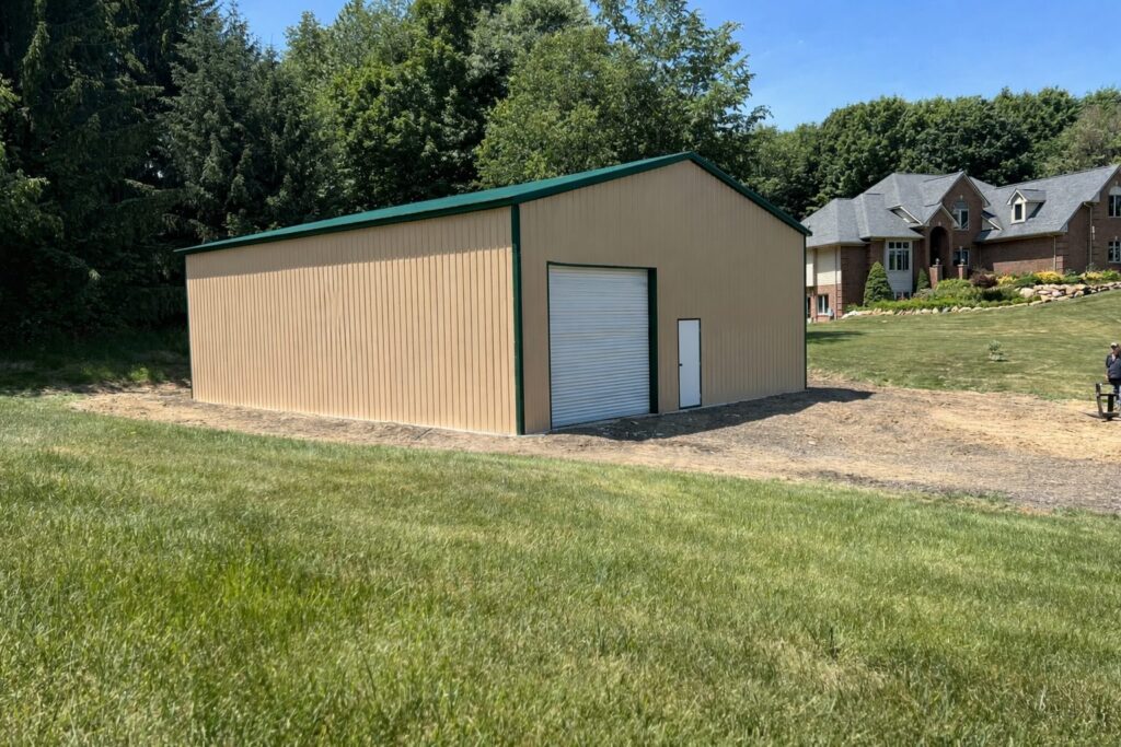 Clear span steel building in Grandview, TX, featuring a beige exterior and green roof, set in a grassy area.