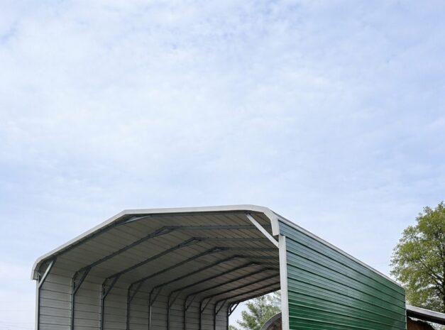 Standard framed carport with a green side, set in a grassy area, showcasing its spacious interior.