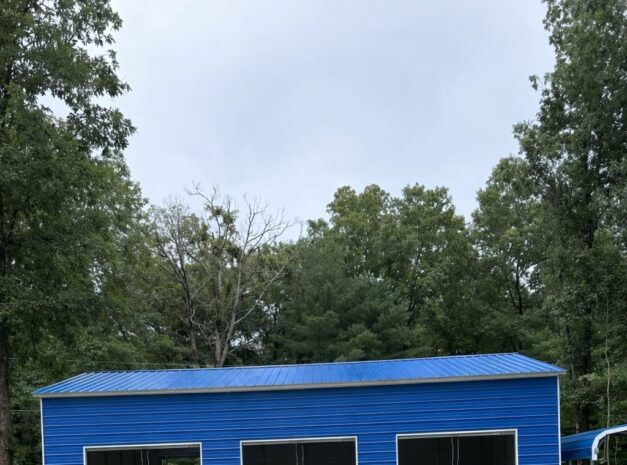 Expansive blue garage with multiple bays, surrounded by trees and gravel driveway, showcasing available color options.