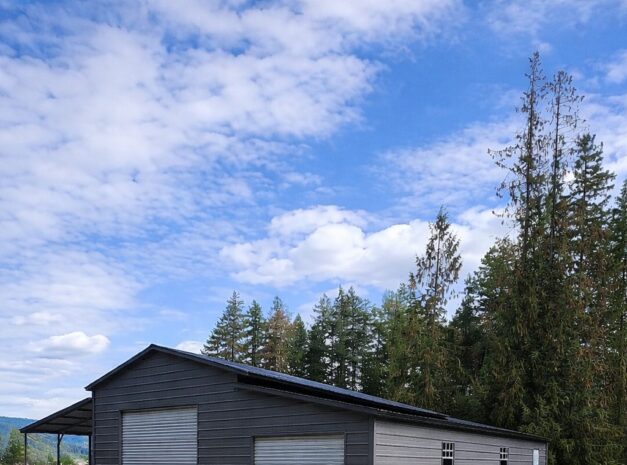 Custom barn structure in Lorain, OH, featuring a gray exterior and roll-up doors, set against a scenic landscape.