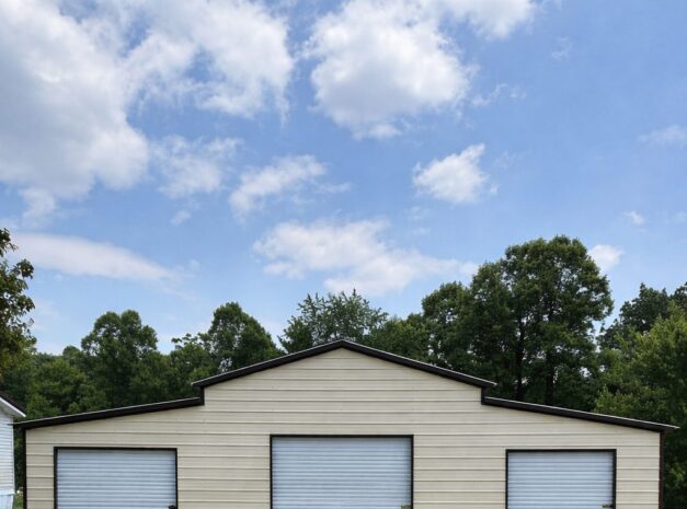 Traditional barn structure in Middletown, OH, featuring three garage doors and a gravel driveway.