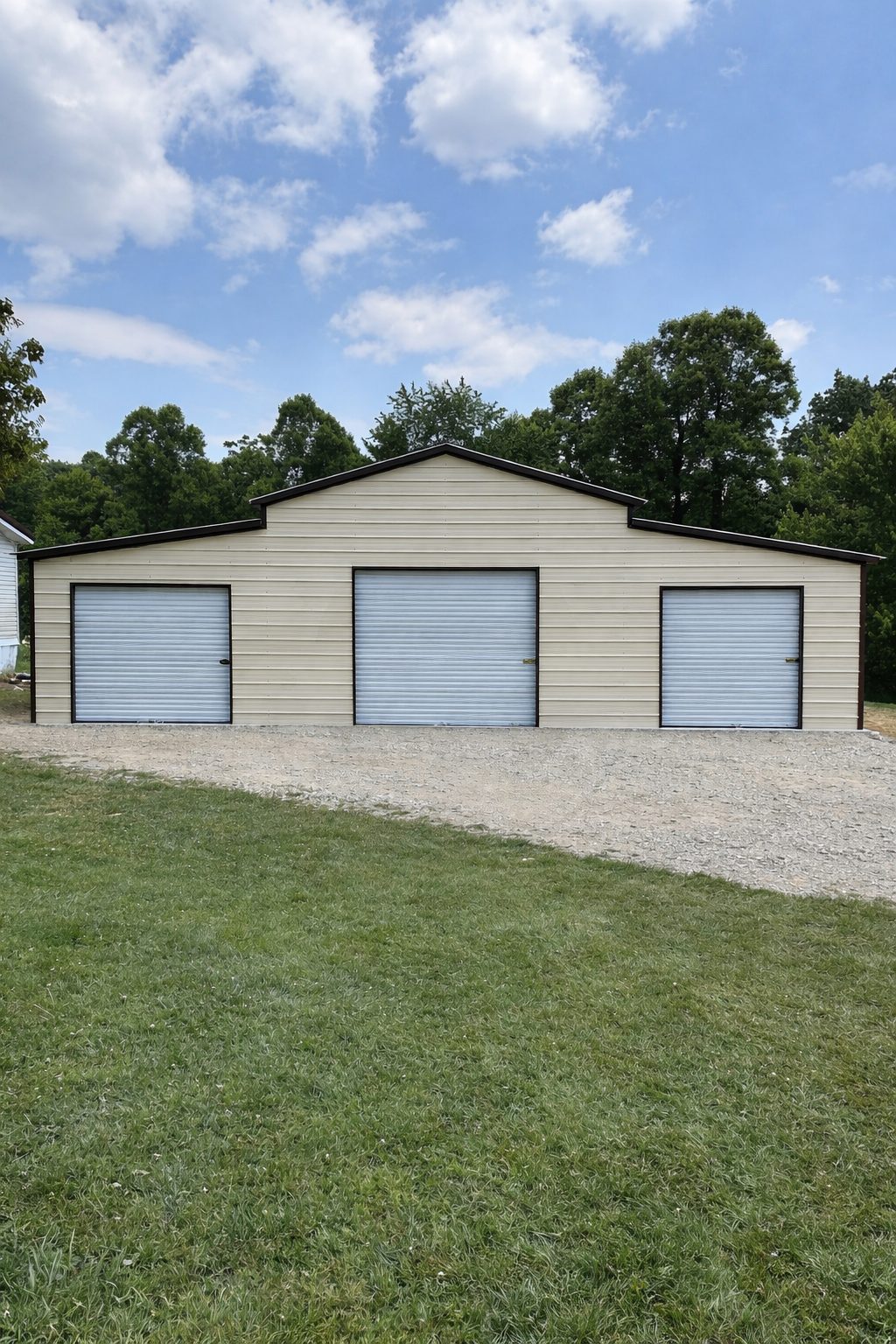 Traditional barn structure in Middletown, OH, featuring three garage doors and a gravel driveway.