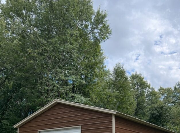 Standard shed in New Boston, TX, featuring brown siding, a roll-up door, and a side entry door.