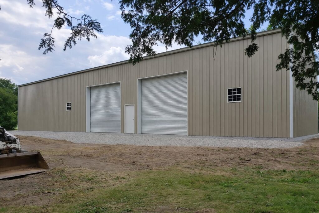 Steel structure building in Poetry, TX, featuring large roll-up doors and a neutral color exterior.