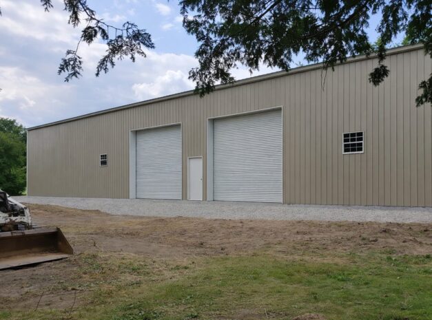 Steel structure building in Poetry, TX, featuring large roll-up doors and a neutral color exterior.