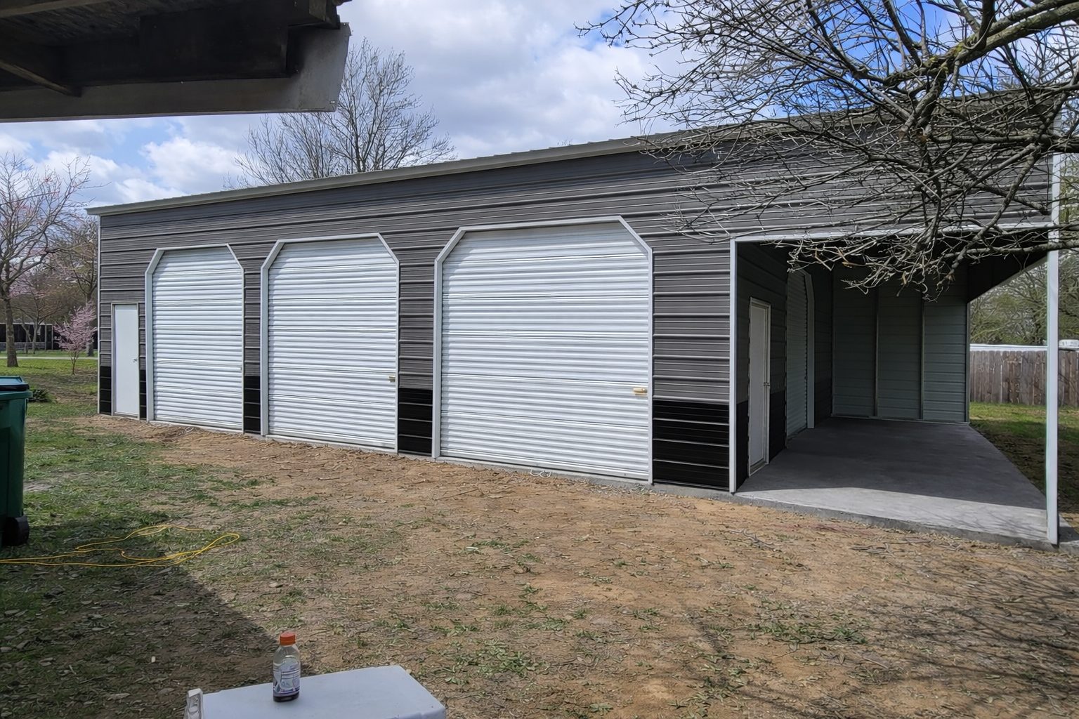 Expansive garage in Standish, MI, featuring multiple roll-up doors and a concrete foundation.