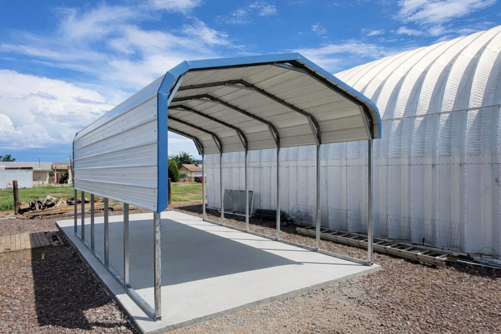 A standard carport structure in Tulsa, featuring a metal frame and a covered roof, set on a concrete base.