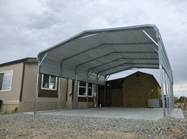 Standard framed carport in Tyler, TX, featuring a metal structure with a concrete base and nearby buildings.